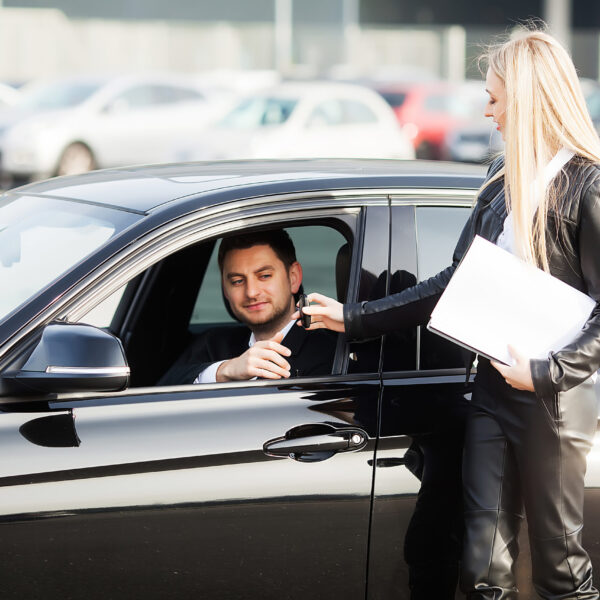 Happy young couple chooses and buying a new car for the family.